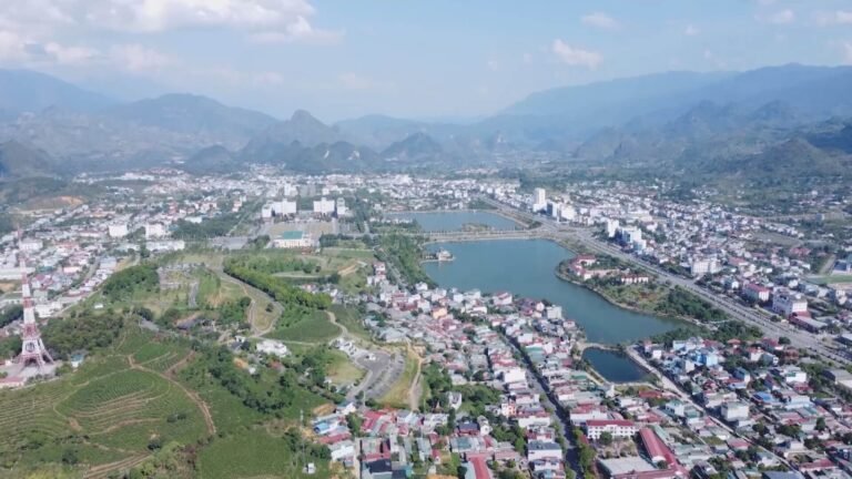 Toàn cảnh thành phố Hòa Bình với sông Đà, tòa nhà và vùng đồi xanh, ánh sáng tự nhiên.