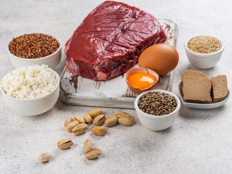 Thịt bò, trứng gà, phô mai và các loại hạt trên bàn, một bữa ăn giàu protein và dinh dưỡng.