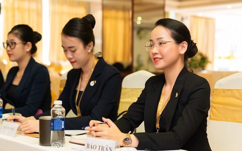 Ba nữ doanh nhân trong buổi hội thảo chuyên nghiệp, mặc trang phục công sở, tập trung và làm việc chăm chỉ.