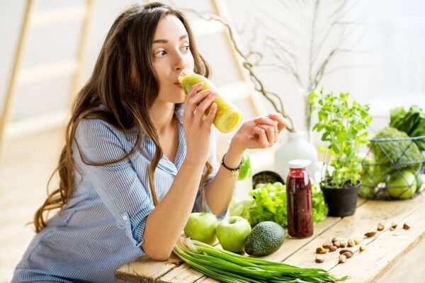 Rau củ và trái cây tươi, cô gái uống sinh tố xanh, không gian bếp hiện đại, sống lành mạnh, thực đơn dinh dưỡng.