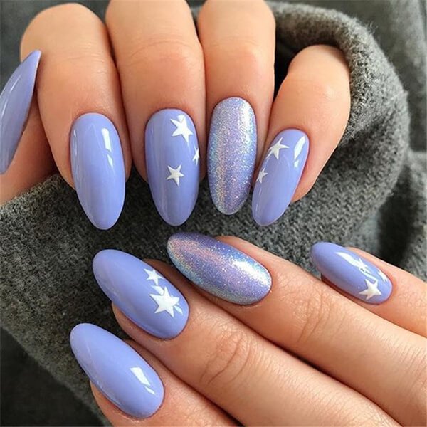Nail màu xanh dương với họa tiết ngôi sao trắng và bóng nhũ lấp lánh.