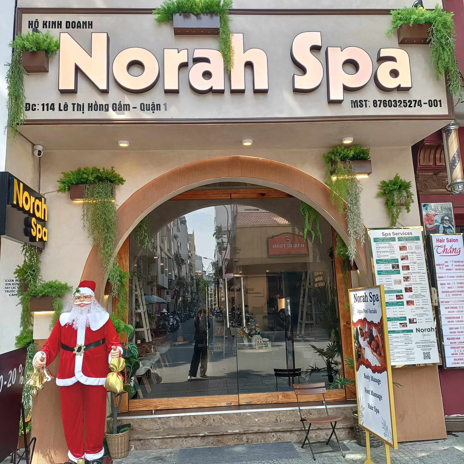 Mặt tiền Norah Spa với tượng ông già Noel và bảng hiệu dịch vụ tại Quận 1, TP. HCM.