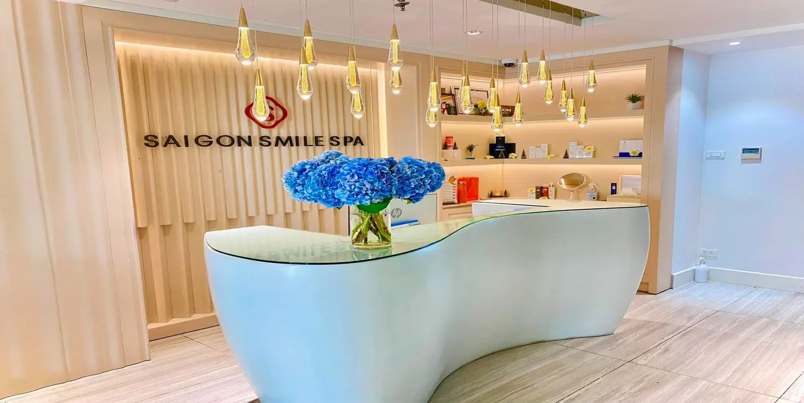Quầy lễ tân tại spa Sài Gòn Smile với hoa cẩm tú cầu và ánh sáng trang nhã.
