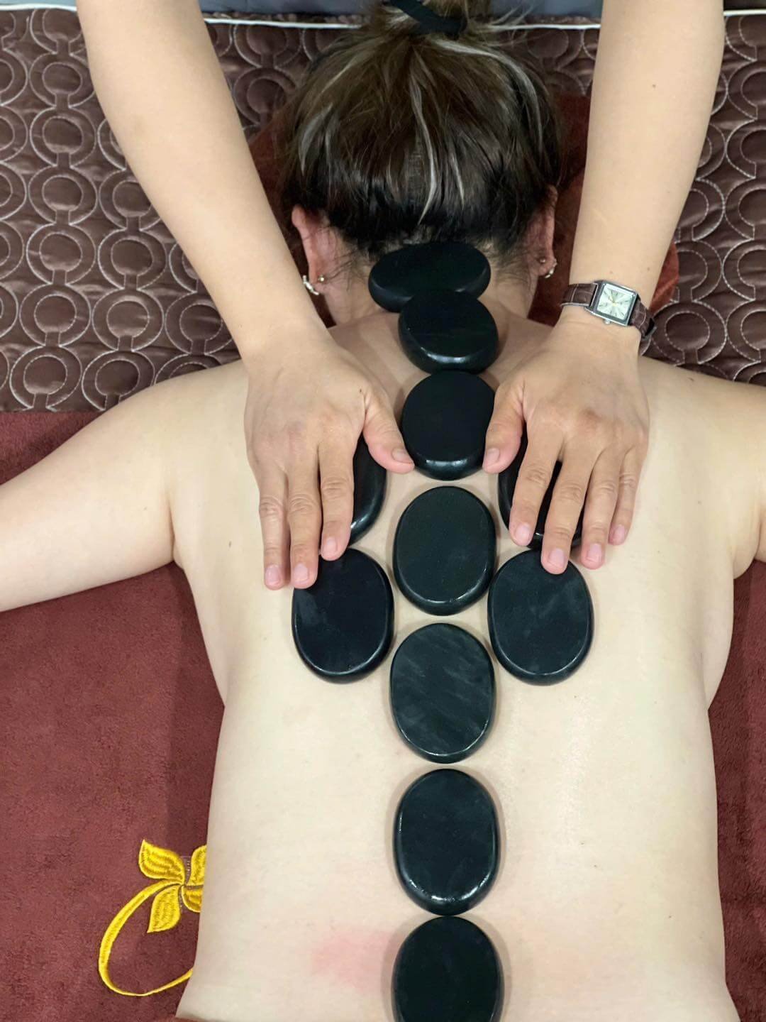 Massage đá nóng thư giãn trên lưng người, giúp giảm căng thẳng và cải thiện sức khỏe.