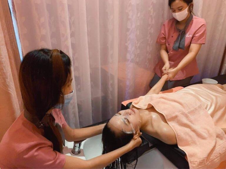 Nhân viên spa chăm sóc khách hàng với dịch vụ massage thư giãn và chăm sóc da mặt.