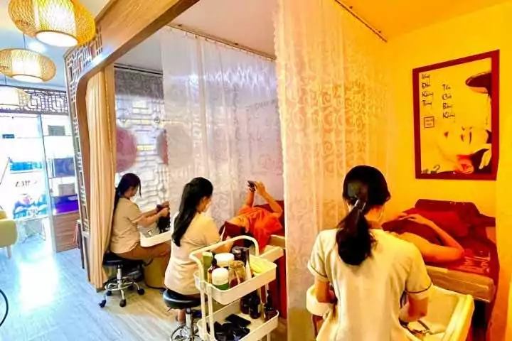 Spa chăm sóc sắc đẹp với hai nhân viên massage cho khách hàng, không gian yên tĩnh và thư giãn.