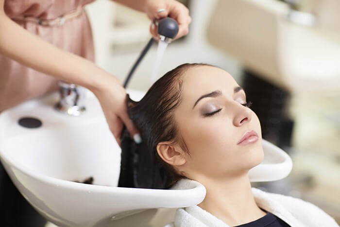 Người phụ nữ thư giãn được gội đầu tại salon tóc chuyên nghiệp.