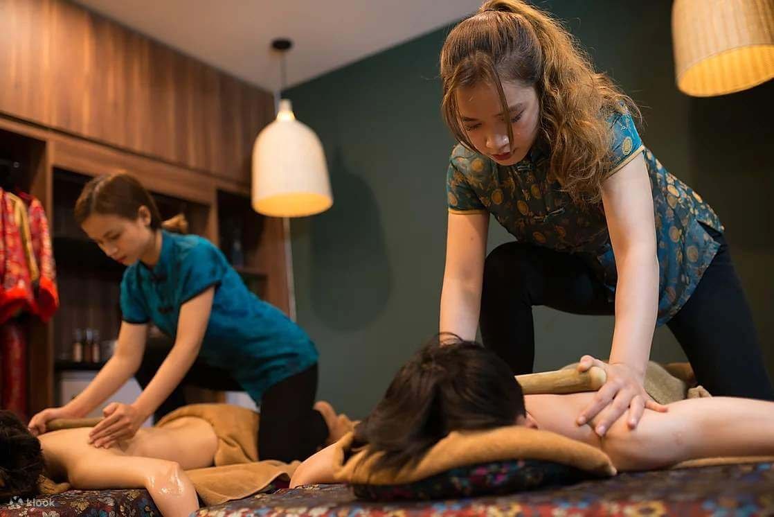 Nhân viên spa thực hiện liệu pháp massage thư giãn cho khách hàng trong không gian ấm áp.