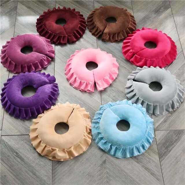 Gối donut nhiều màu sắc, bọc rìa ren, xếp trên sàn gỗ.