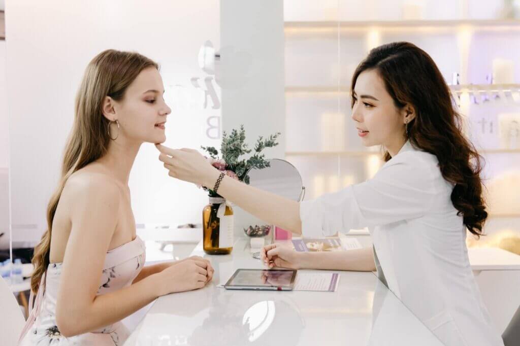 Chuyên gia da liễu tư vấn khách hàng tại phòng khám thẩm mỹ.