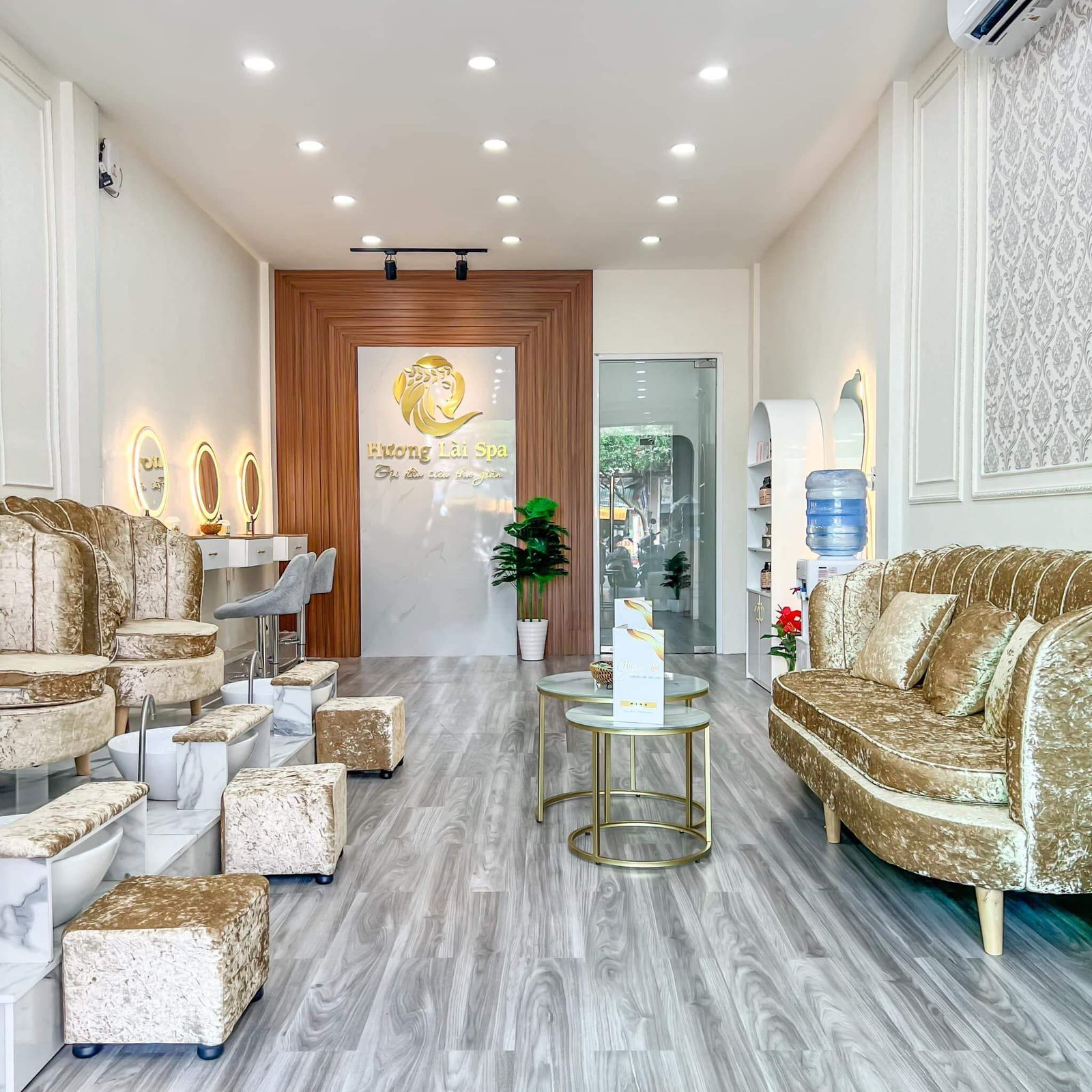 Spa sang trọng với nội thất mạ vàng, ánh sáng hiện đại, không gian thoải mái và ghế sofa tiện nghi.