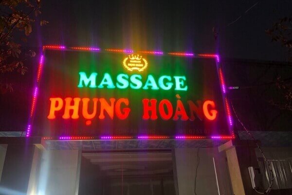 Biển hiệu quán Massage Phụng Hoàng rực rỡ đèn LED màu sắc, nổi bật trong bóng tối.