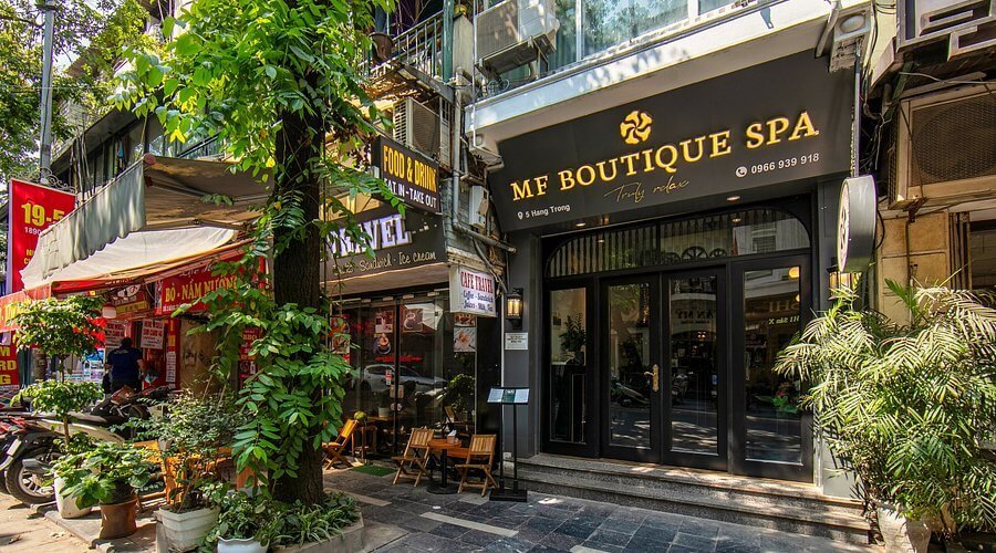 Mặt tiền Mẹ Boutique Spa tại phố Hà Nội, xung quanh là quán ăn và cây xanh.