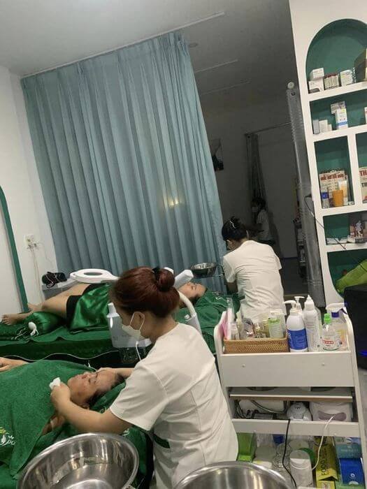 Nhân viên spa chăm sóc da cho khách hàng trong phòng trị liệu, thư giãn với ánh sáng dịu và không gian sạch sẽ.