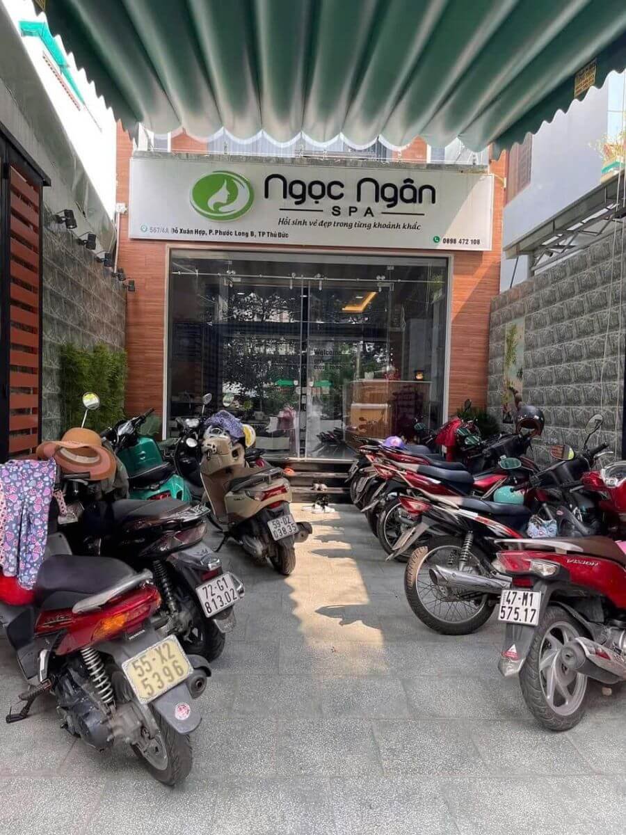 Xe máy đậu trước Ngọc Ngân Spa, Phước Long B, Thủ Đức, với tấm bạt che nắng xanh.