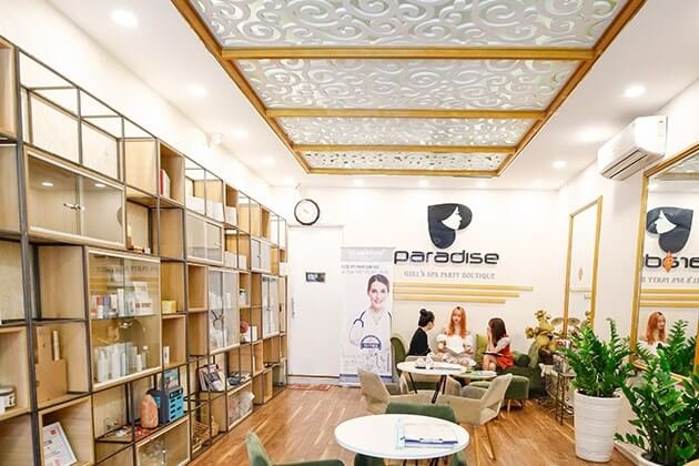 Không gian nội thất sang trọng của spa với khách hàng và nhân viên trao đổi tại bàn tròn, trang trí hiện đại.