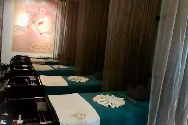 Phòng spa sang trọng với giường massage, khăn tắm xếp gọn, và ánh sáng dịu nhẹ tạo không gian thư giãn.