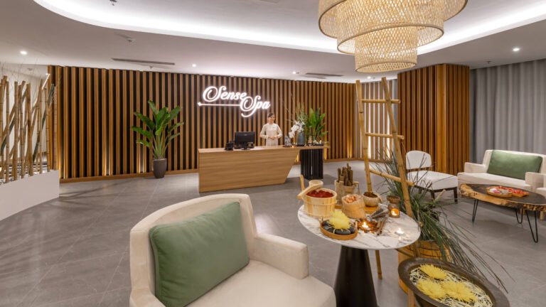 Khu vực tiếp tân của spa với nội thất gỗ sang trọng và bàn trang trí với nến và hoa.
