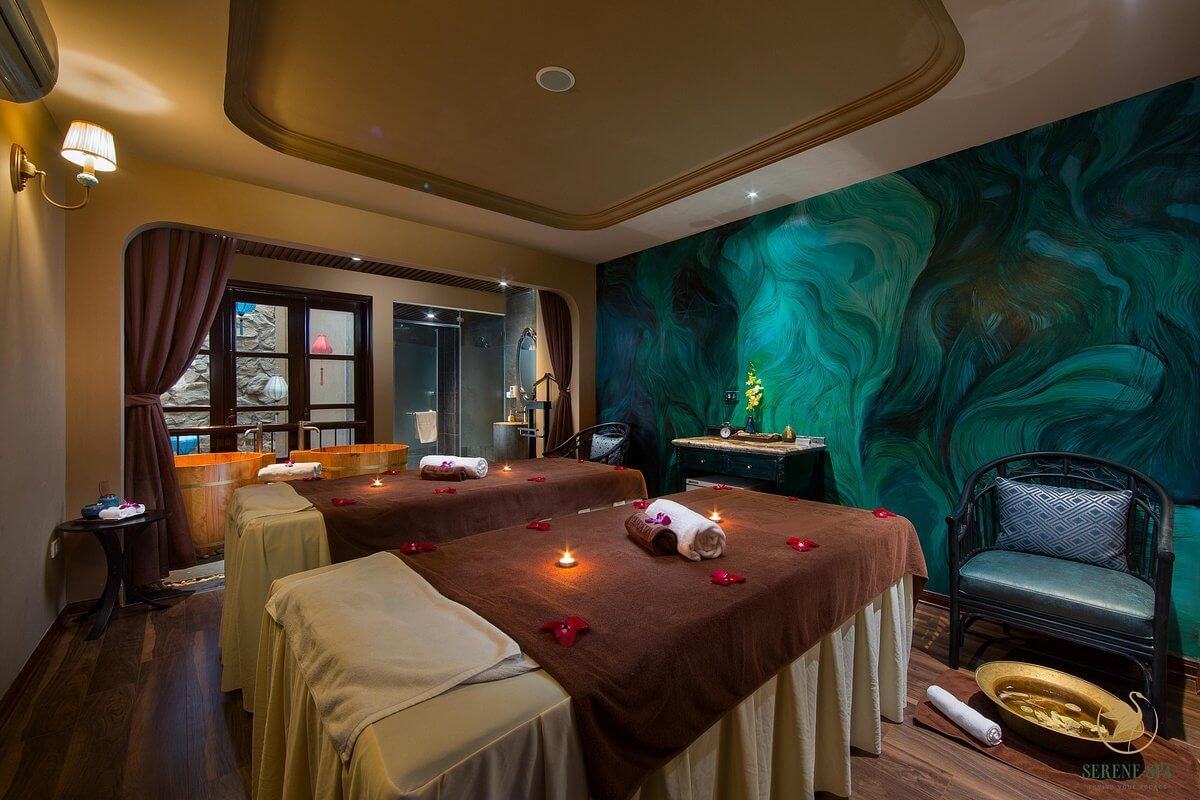 Phòng spa thư giãn với giường massage, nến và hoa, thiết kế nội thất sang trọng và ấm cúng.