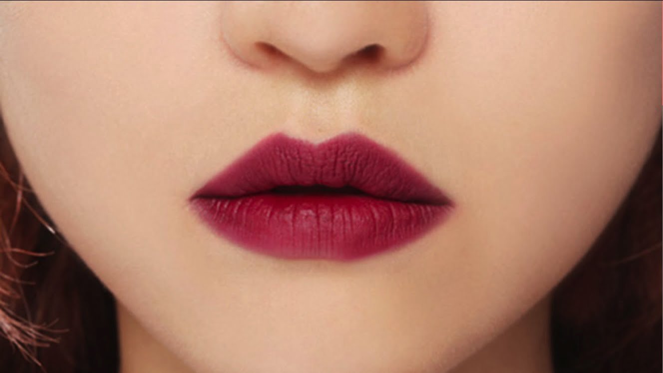 Đôi môi được tô son đỏ đậm, tạo cảm giác quyến rũ và nổi bật trên nền da sáng.