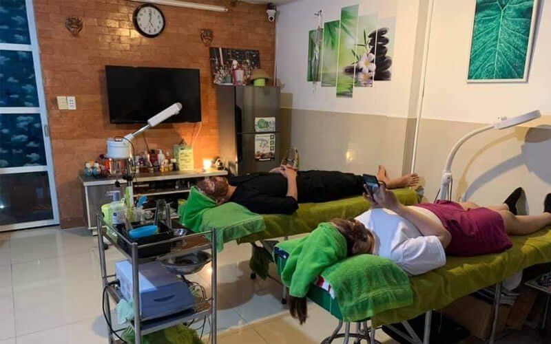 Hai người nằm thư giãn trên giường massage tại spa, không gian ấm cúng với ánh sáng dịu nhẹ.