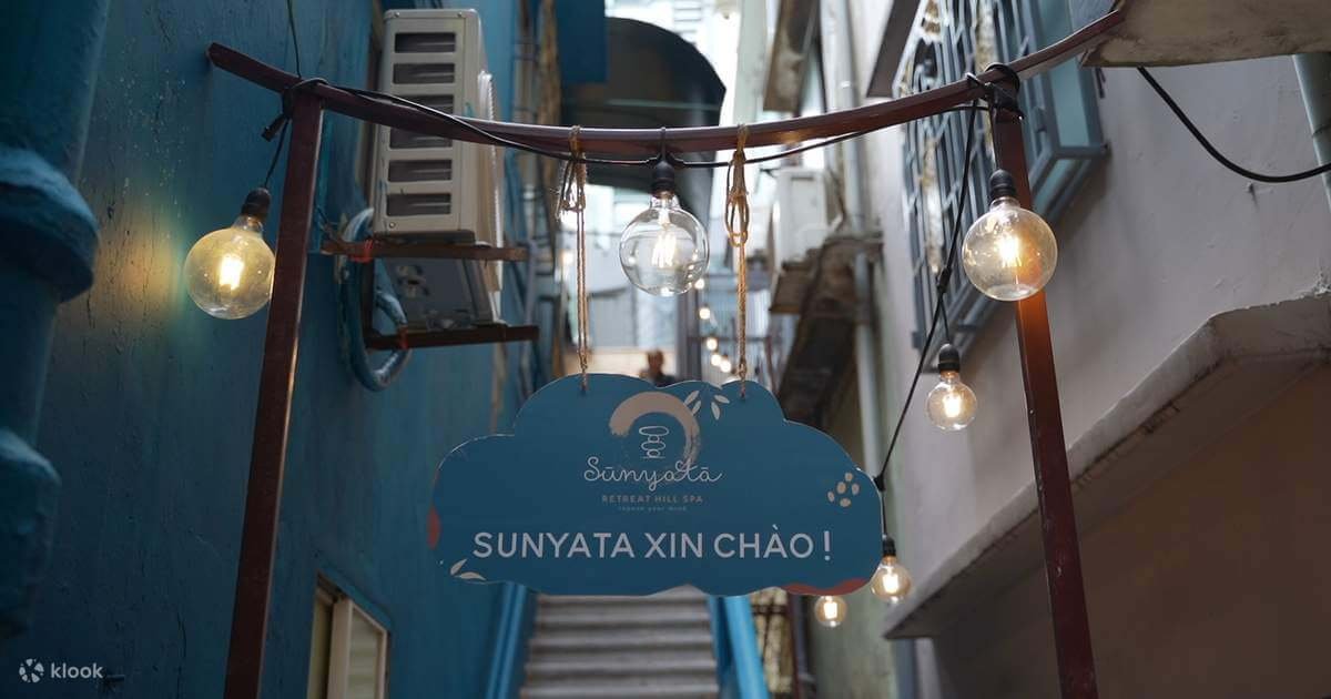 Biển hiệu Sunyata Retreat Hill Spa treo trong hẻm nhỏ với đèn dây lung linh.
