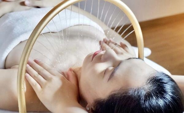 Người phụ nữ thư giãn trong liệu pháp massage với vòng ánh sáng, tạo cảm giác yên bình và nhẹ nhàng.