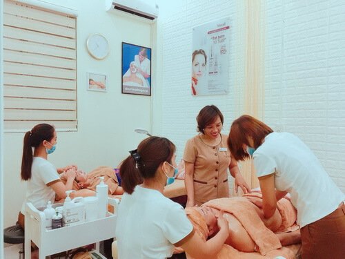 Nhân viên spa chăm sóc khách tại phòng dịch vụ, tạo không gian thư giãn và chuyên nghiệp với trang thiết bị hiện đại.