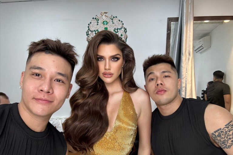 Ba người chụp ảnh selfie, một người phụ nữ đội vương miện và hai người đàn ông, trong phòng trang điểm.