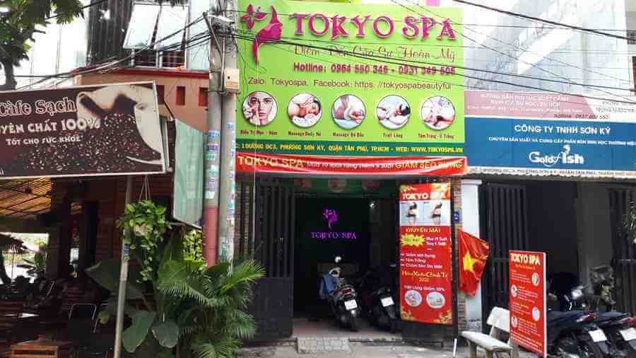 Mặt tiền Tokyo Spa với bảng hiệu màu sắc và quảng cáo các dịch vụ massage, chăm sóc da tại thành phố.