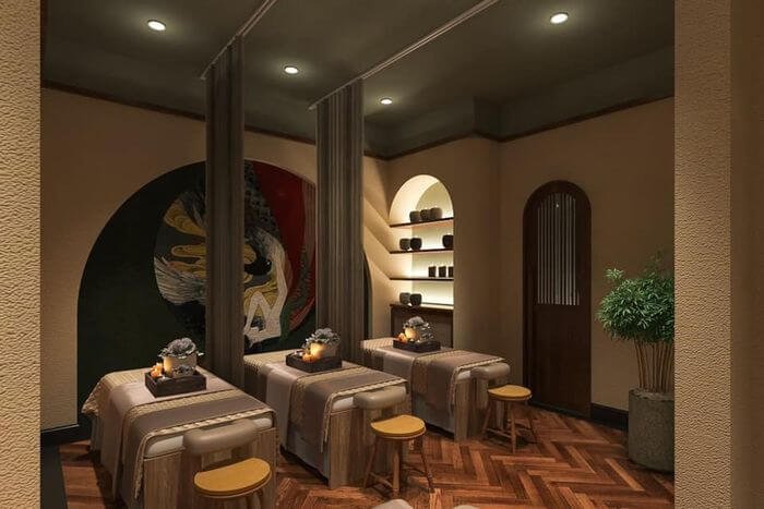 Phòng spa sang trọng với ba giường massage, ánh sáng dịu nhẹ và trang trí ấm cúng.