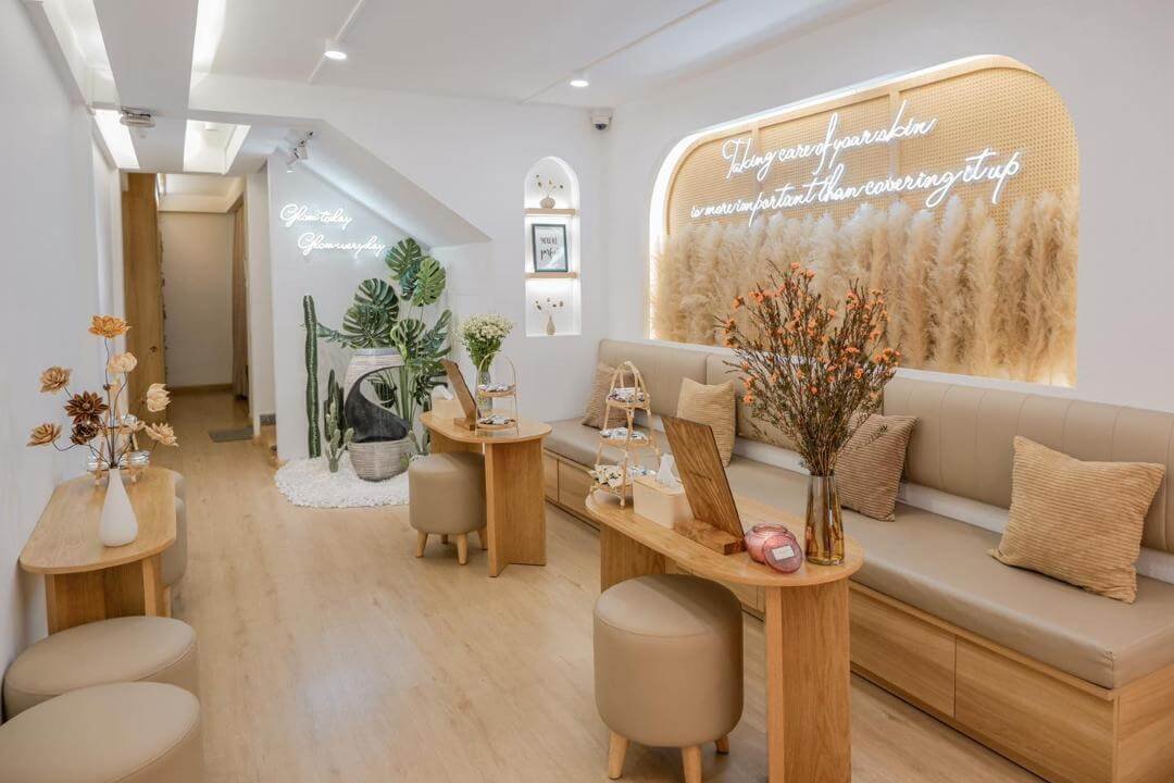 Phòng tiếp khách hiện đại với trang trí cây xanh và bảng đèn neon, tạo không gian thư giãn và thoải mái.
