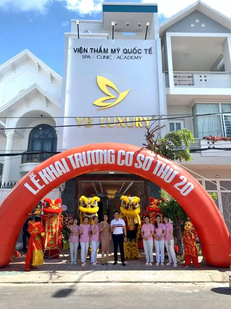 Khai trương chi nhánh thứ 20 của Viện Thẩm Mỹ Quốc Tế YB Luxury với múa lân và đội ngũ nhân viên trước cửa.