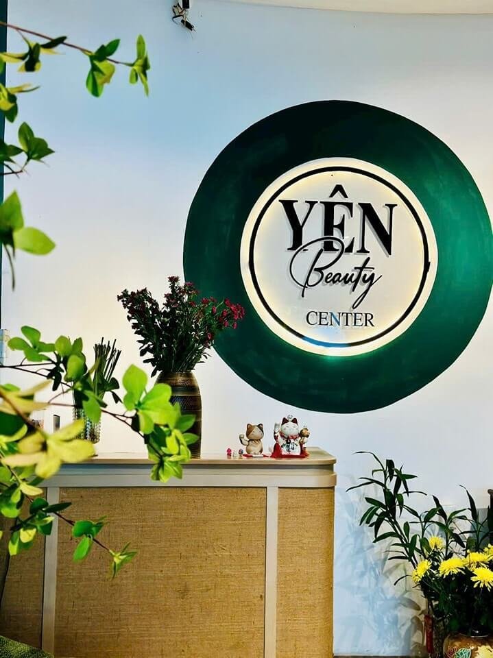 Quầy lễ tân Yên Beauty Center với trang trí cây xanh và tượng mèo may mắn.