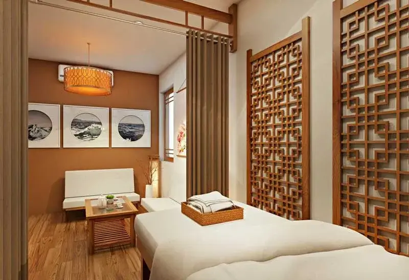 Phòng spa trang trí theo phong cách Nhật Bản với giường massage, tranh treo tường và vách ngăn gỗ họa tiết.