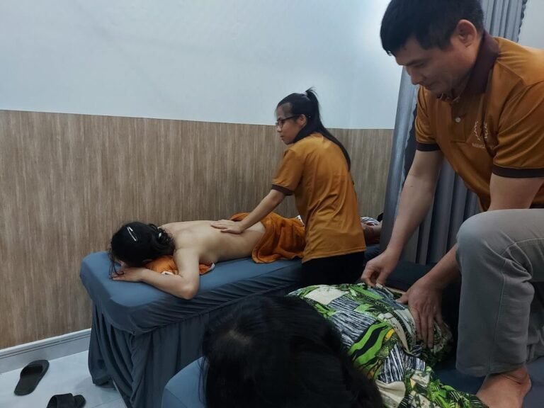 Nhân viên massage chuyên nghiệp đang phục vụ khách hàng trong spa thư giãn.