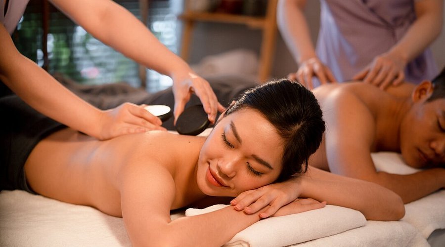 Người phụ nữ và người đàn ông thư giãn trong liệu trình massage tại spa, tận hưởng dịch vụ chăm sóc sức khỏe.