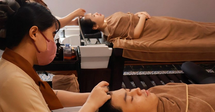 Nhân viên spa chăm sóc khách hàng, thư giãn trong không gian ấm cúng, hai người đắp chăn.