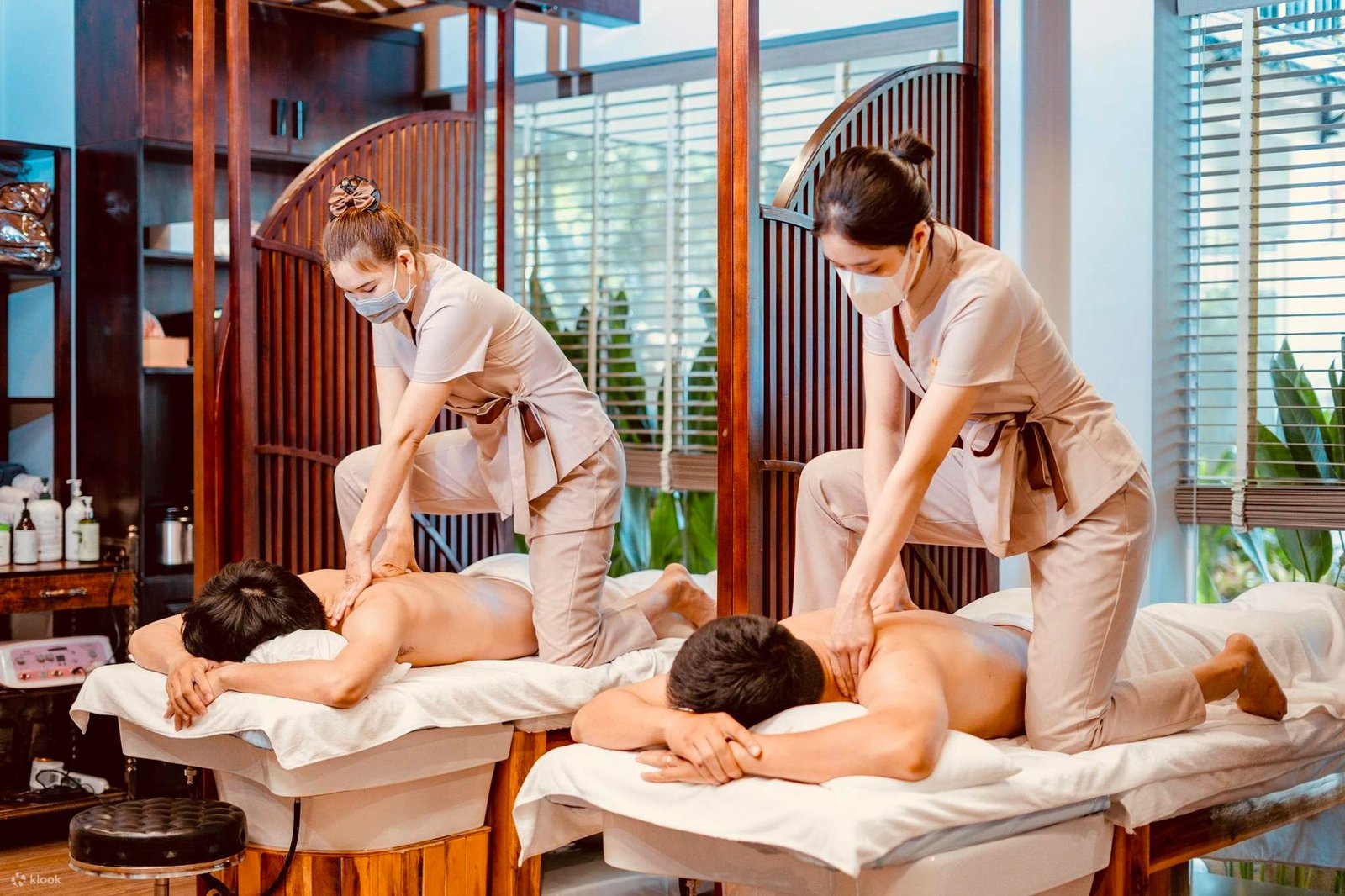 Nhân viên spa đang thực hiện trị liệu massage cho khách hàng tại phòng thư giãn.