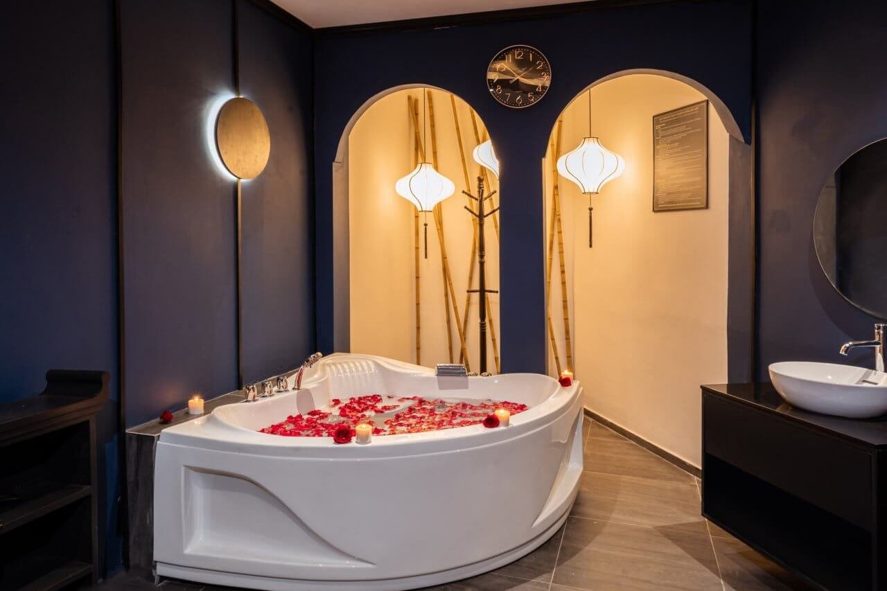 Bồn tắm sang trọng với hoa hồng và nến, tạo không gian thư giãn ấm cúng trong phòng tắm hiện đại.