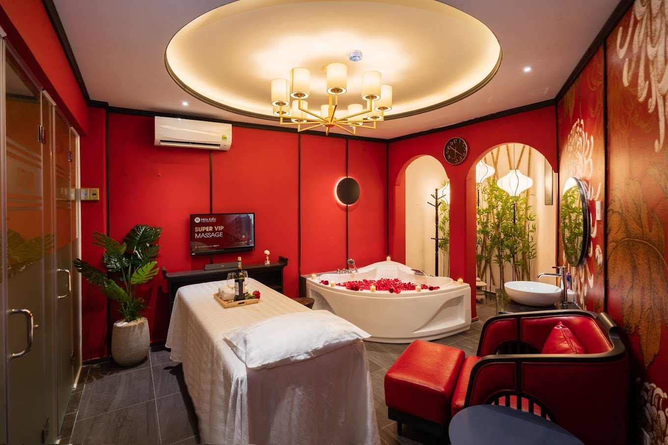 Phòng spa sang trọng với bồn tắm hoa hồng và đèn chùm, tạo không gian thư giãn tuyệt vời.