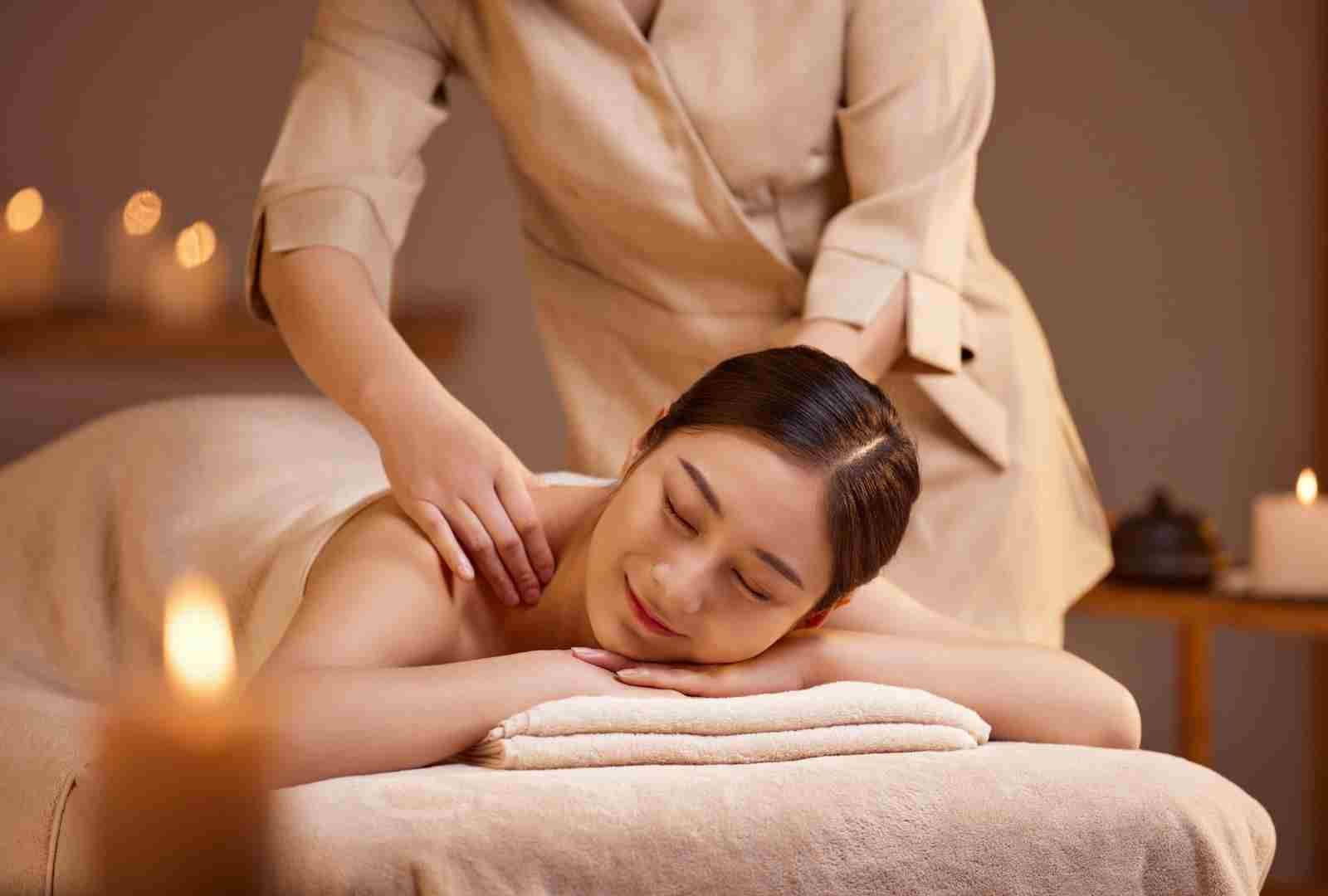 Người phụ nữ thư giãn trong spa với liệu pháp massage, ánh sáng nến tạo không gian ấm áp và yên bình.