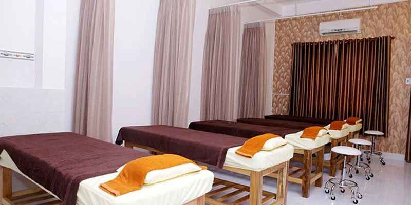 Phòng spa thư giãn với giường trị liệu, rèm và ánh sáng dịu, tạo không gian yên tĩnh và thoải mái cho khách hàng.
