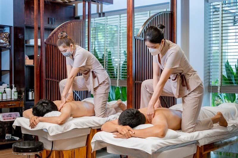 Nhân viên massage chuyên nghiệp thực hiện liệu pháp thư giãn cho khách hàng tại spa sang trọng.