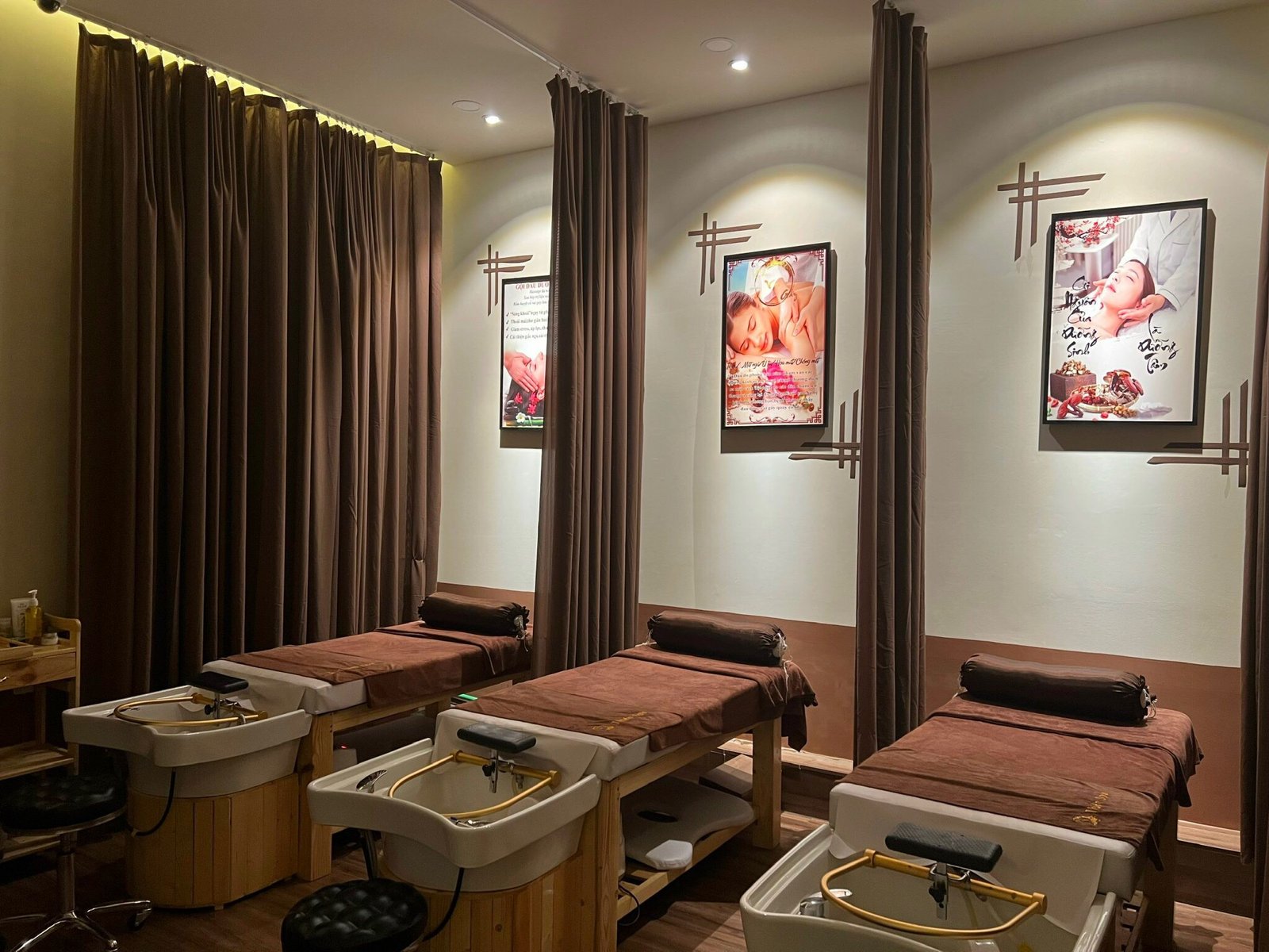 Phòng spa thư giãn với giường massage, ánh sáng ấm áp, tranh trang trí trên tường.