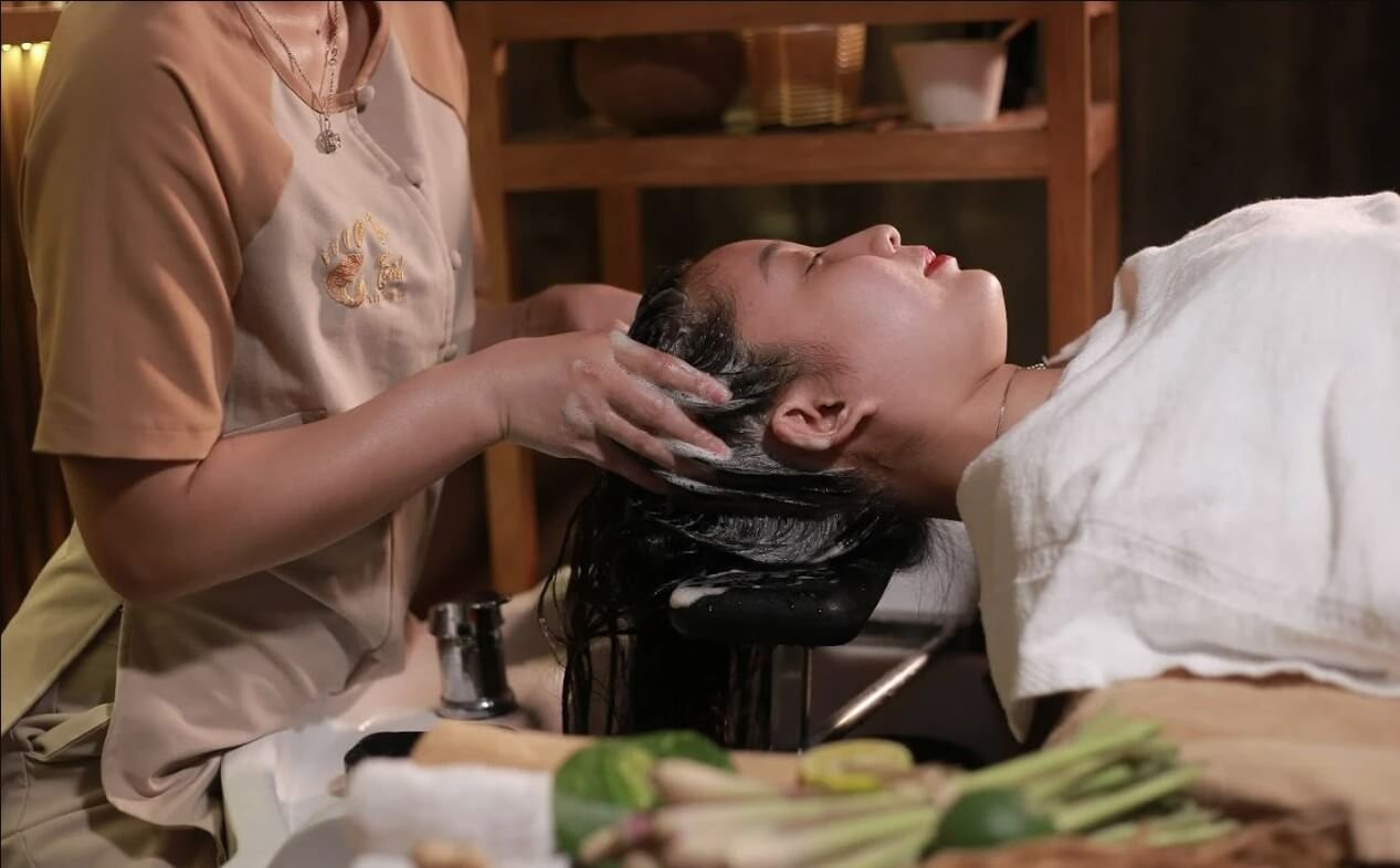 Nhân viên salon đang gội đầu và massage cho khách hàng thư giãn tại spa.