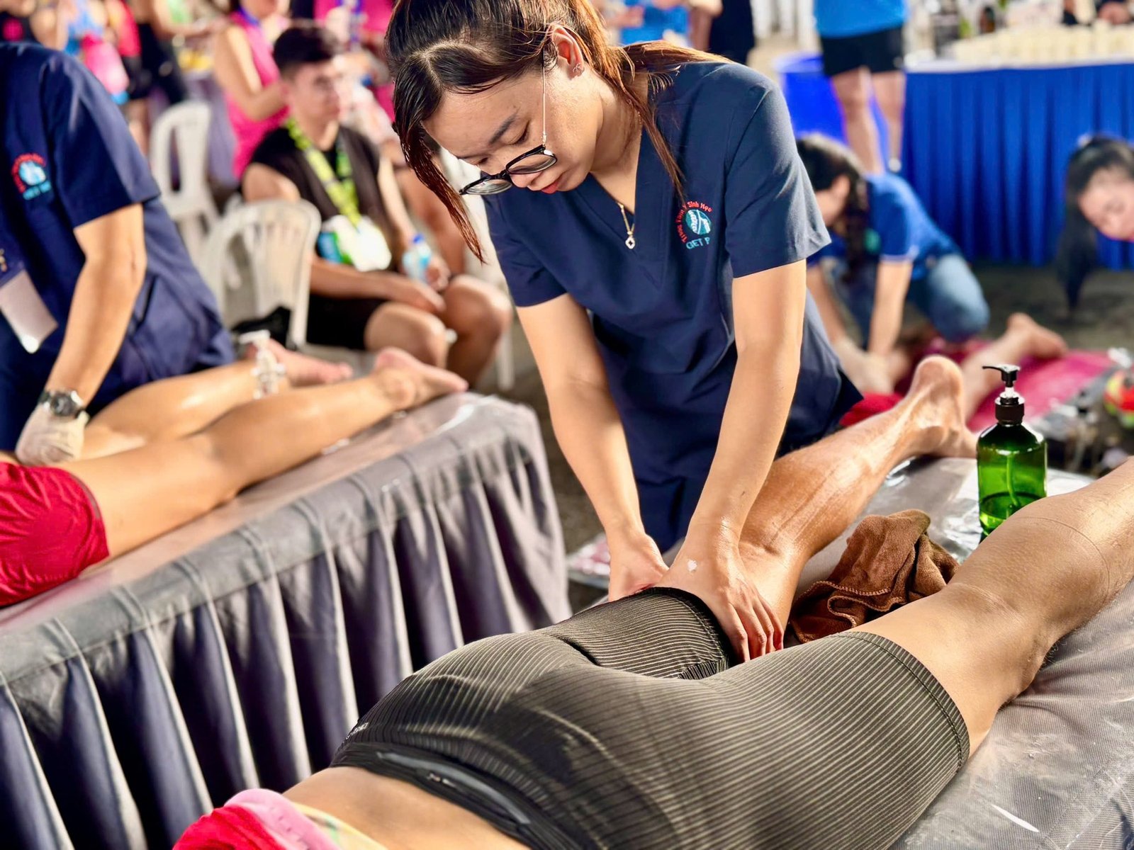 Nhân viên mát-xa chuyên nghiệp thực hiện liệu pháp thư giãn cho khách hàng trên bàn mát-xa.