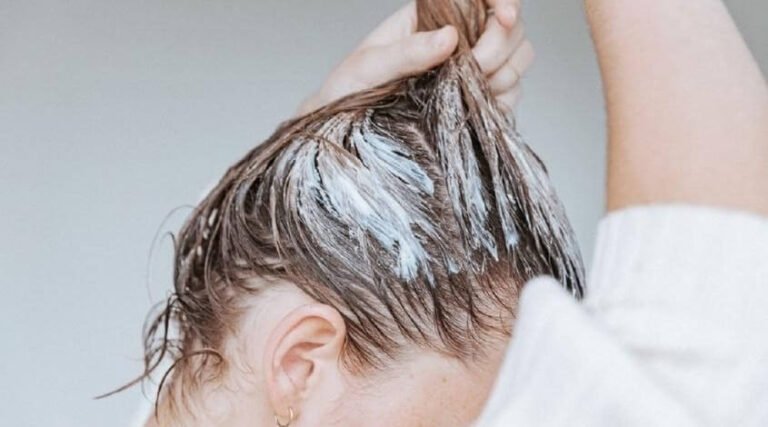 Người phụ nữ đang bôi kem dưỡng lên tóc ướt, chăm sóc tóc, khôi phục độ ẩm, làm đẹp tóc tại nhà.