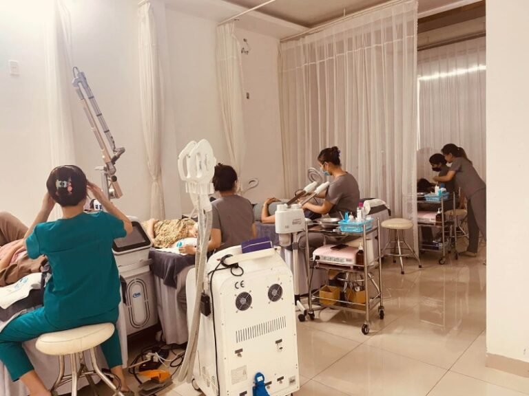 Nhân viên thẩm mỹ viện thực hiện chăm sóc da mặt cho khách hàng, sử dụng thiết bị công nghệ cao trong không gian spa.