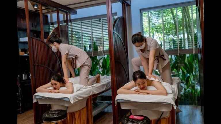 Nhân viên massage thực hiện liệu pháp thư giãn cho khách hàng tại spa, không gian tràn ngập ánh sáng và cây xanh.